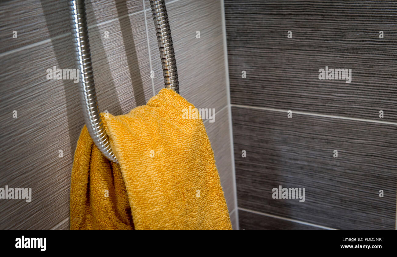 Serviette couleur or pendu dans une salle de bains de style contemporain. Banque D'Images