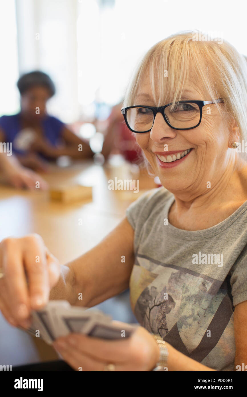 Portrait of happy woman cartes à jouer dans un centre communautaire Banque D'Images