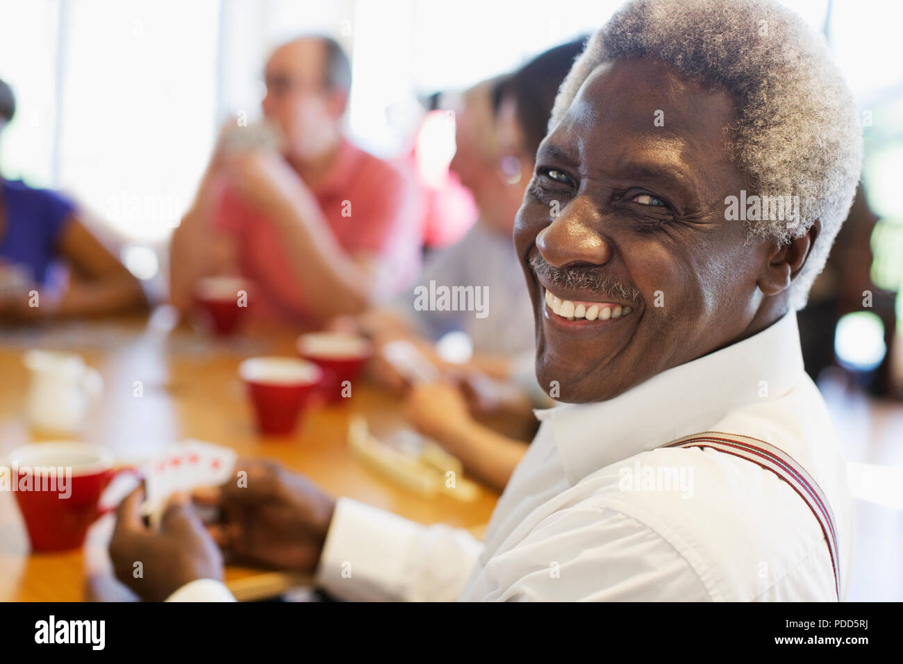 Portrait happy senior man jouer aux cartes avec des amis au centre communautaire Banque D'Images
