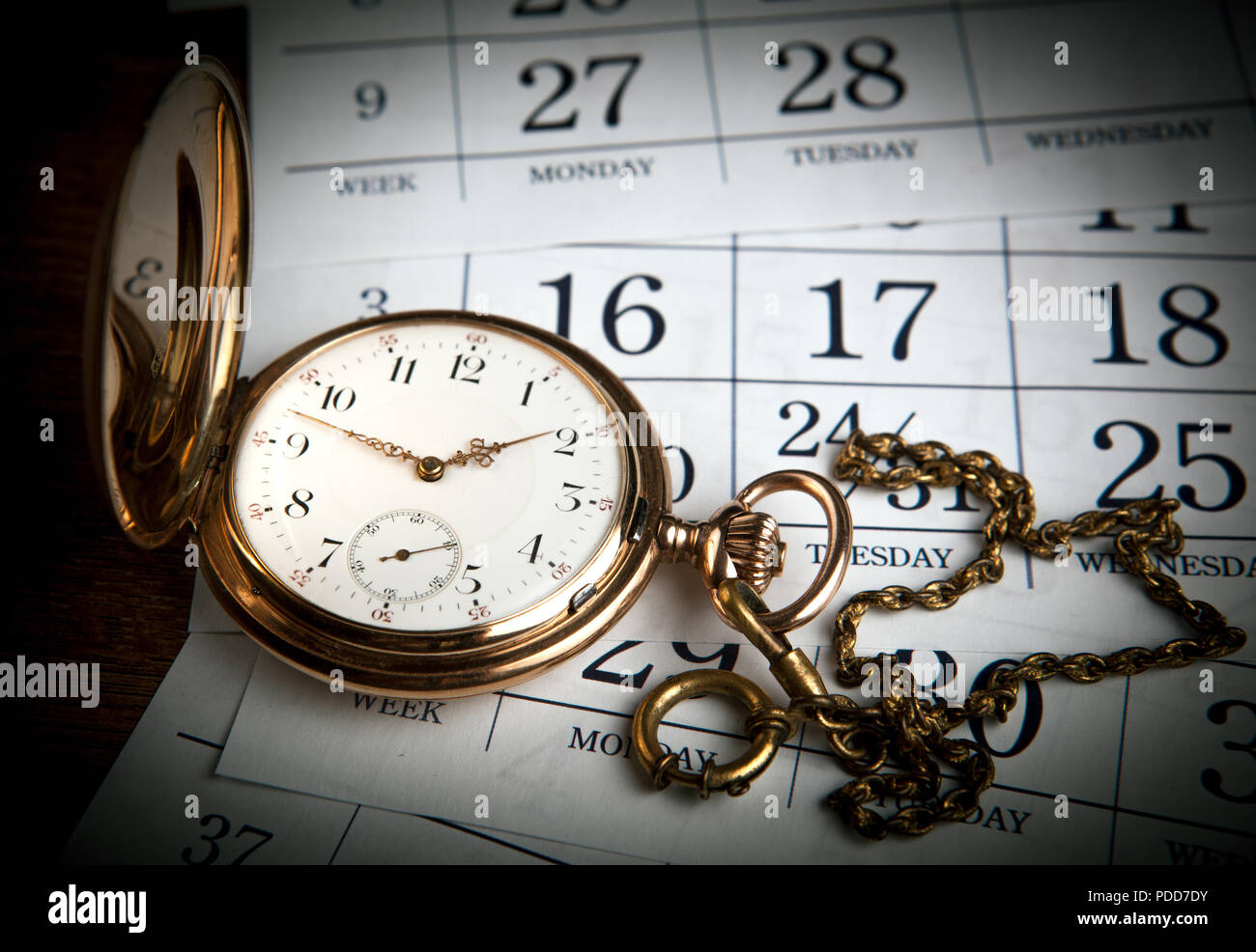 Une ancienne montre en or se trouve sur feuilles de calendrier Banque D'Images