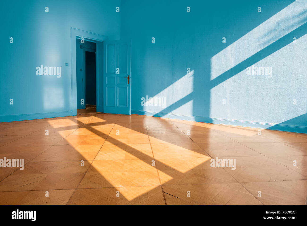 Vide lumineux appartement chambre avec des murs bleus et de sol en bois - Banque D'Images