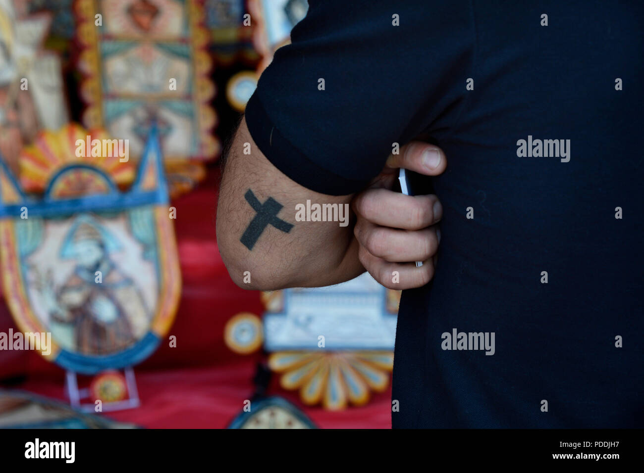 Un homme ayant tatoué sur son bras tenant un smartphone tout en regardant les œuvres d'espagnol. Banque D'Images