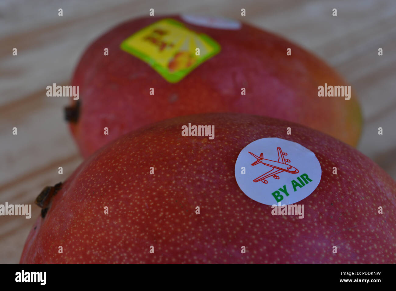 Par Air autocollant sur la mangue fraîche de fruits dans un supermarché au Royaume-Uni. Image conceptuelle, l'empreinte carbone. Banque D'Images