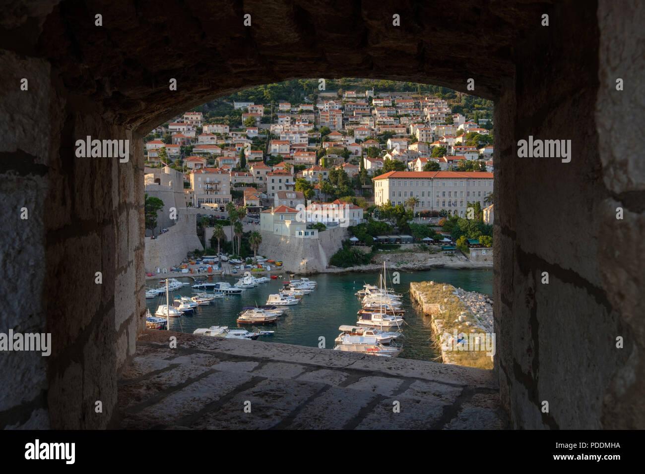 Bateaux sur le port de plaisance de la vieille ville vue à travers un trou sur les murs de la ville de Dubrovnik, Croatie, Europe Banque D'Images