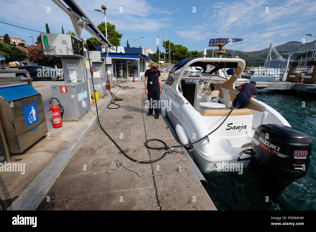 Ravitaillement des gens un hors-bord à une station service Banque D'Images