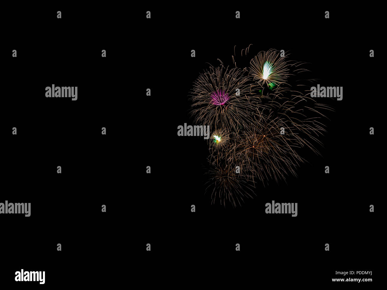 D'artifice multicolores au-dessus de l'océan dans la grande ville, des immeubles modernes sur l'arrière-plan, rougeoyant et reflétant des feux de salve sur l'eau, les gens w Banque D'Images