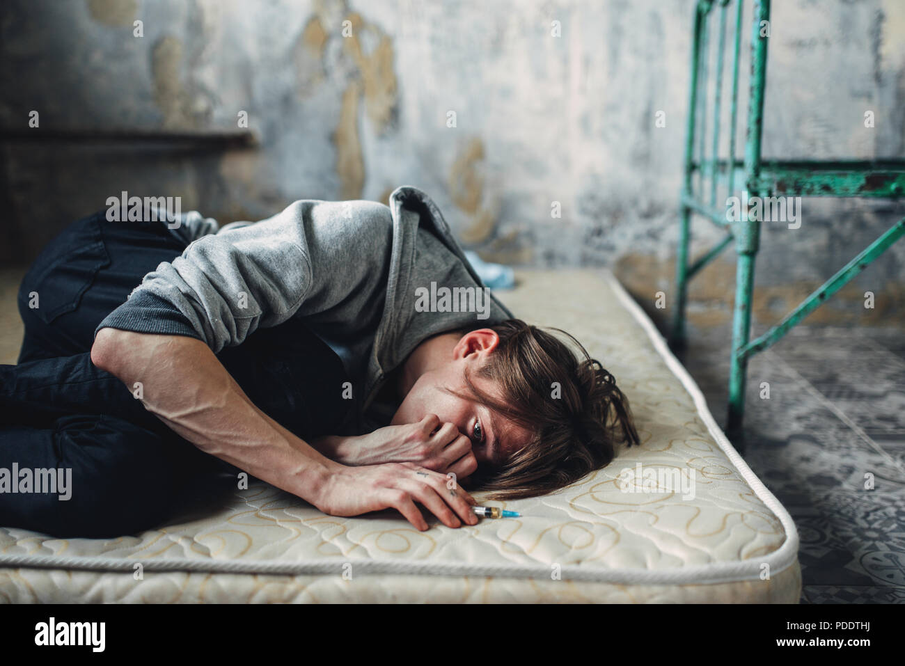 Homme toxicomane sleeping in bed après la dose Banque D'Images