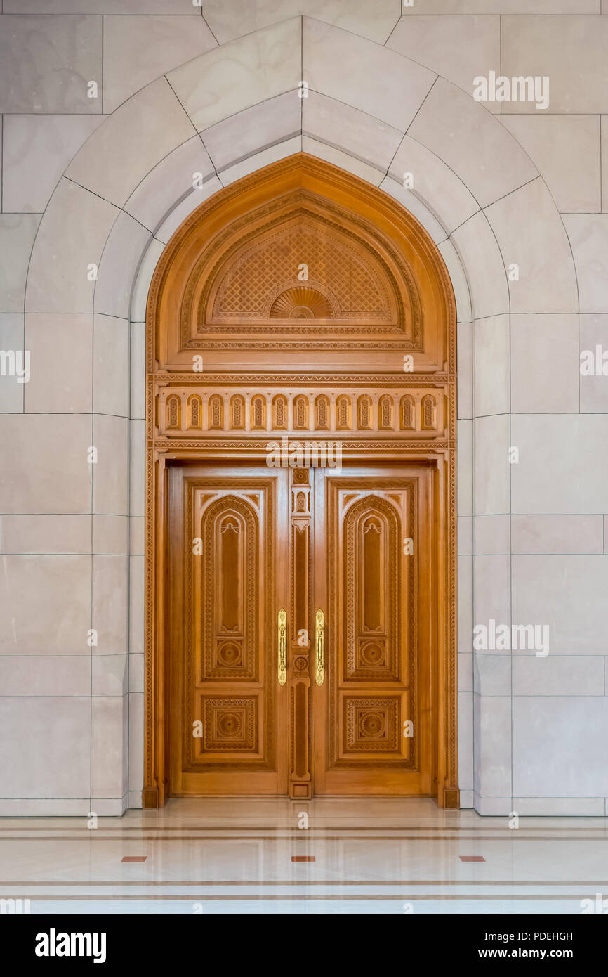 Porte en bois finement sculptés dans un style arabe traditionnel trouvé sur l'entrée d'un nouveau bâtiment à Muscat, Oman Banque D'Images