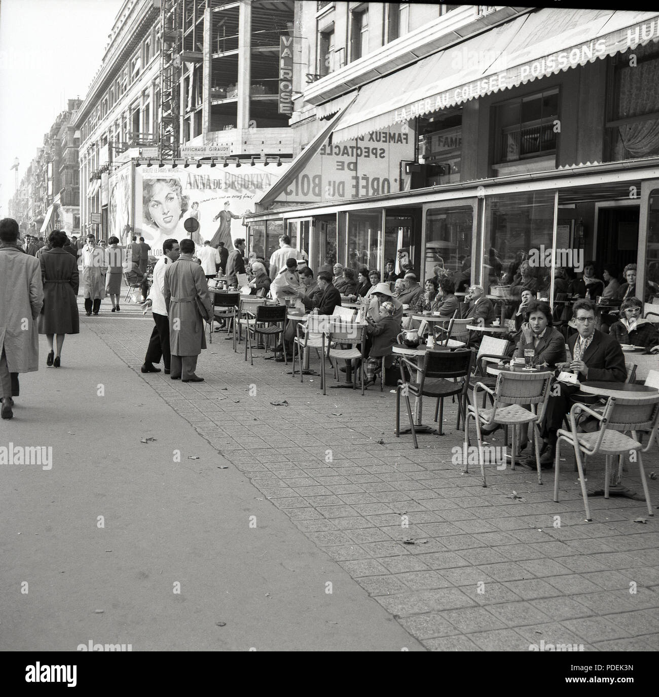 Années 1950, Paris, France, les parisiens assis à l'extérieur d'un café de l'avenue des Champs-Elysées, le célèbre boulevard. Banque D'Images