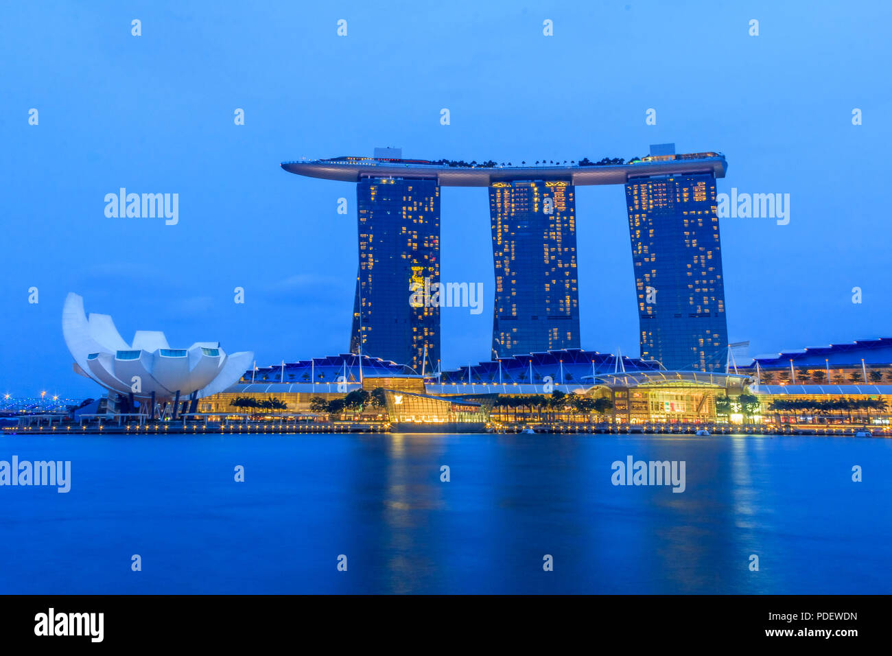 Singapour, Singapour - 20 janvier : Le conseil de l'hôtel en forme de surf luxueuses et Marina Bay Sands casino et lotus-musée ArtScience inspiré après le coucher du soleil Banque D'Images