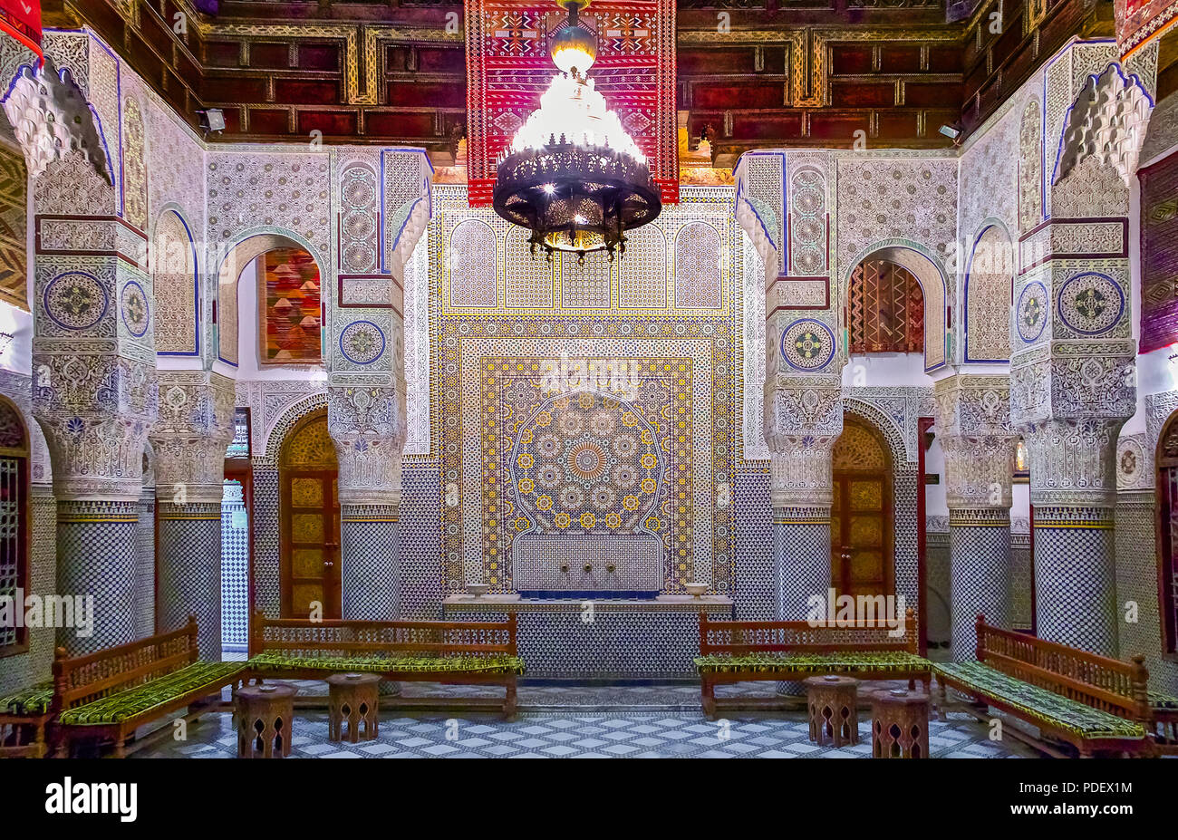 Fes, Maroc - 11 mai 2013 : cour intérieure décorée avec des mosaïques et des sculptures en arabesque, avec divans traditionnel dans un riad marocain Banque D'Images