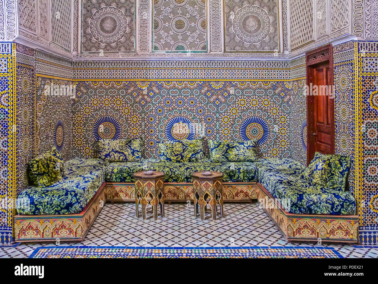 Fes, Maroc - 11 mai 2013 : cour intérieure décorée avec des mosaïques et des sculptures en arabesque, avec divans traditionnel dans un riad marocain Banque D'Images