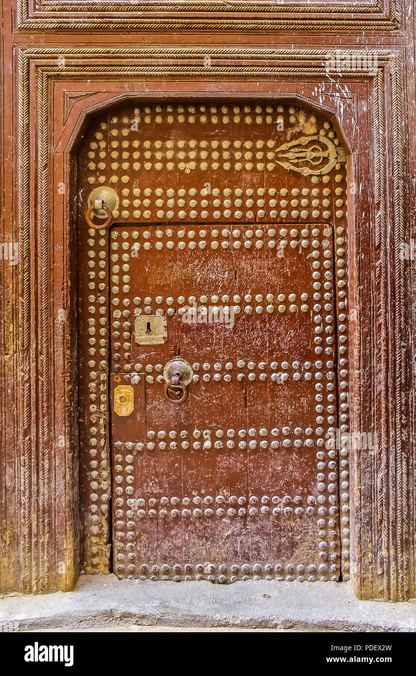 Ancienne en bois finement sculptée, porte cloutée et porte cadre,d'une maison marocaine traditionnelle à Fes, Maroc Banque D'Images