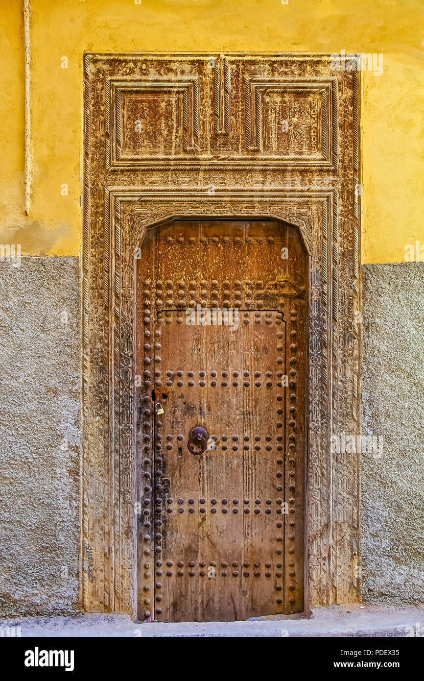 Ancienne en bois finement sculptée, porte cloutée et porte cadre,d'une maison marocaine traditionnelle à Fes, Maroc Banque D'Images