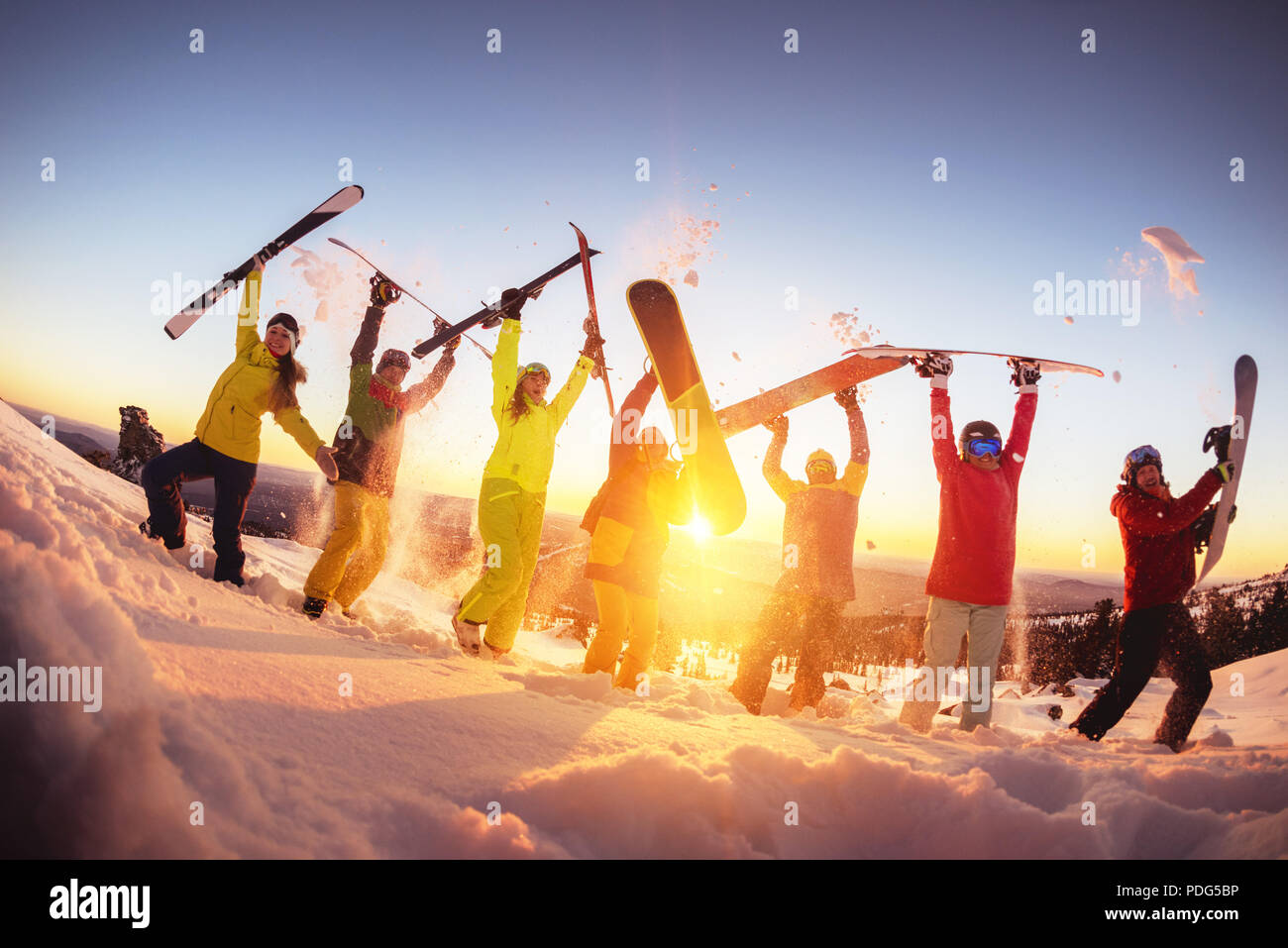 Happy friends at ski resort s'amusant coucher du soleil Banque D'Images