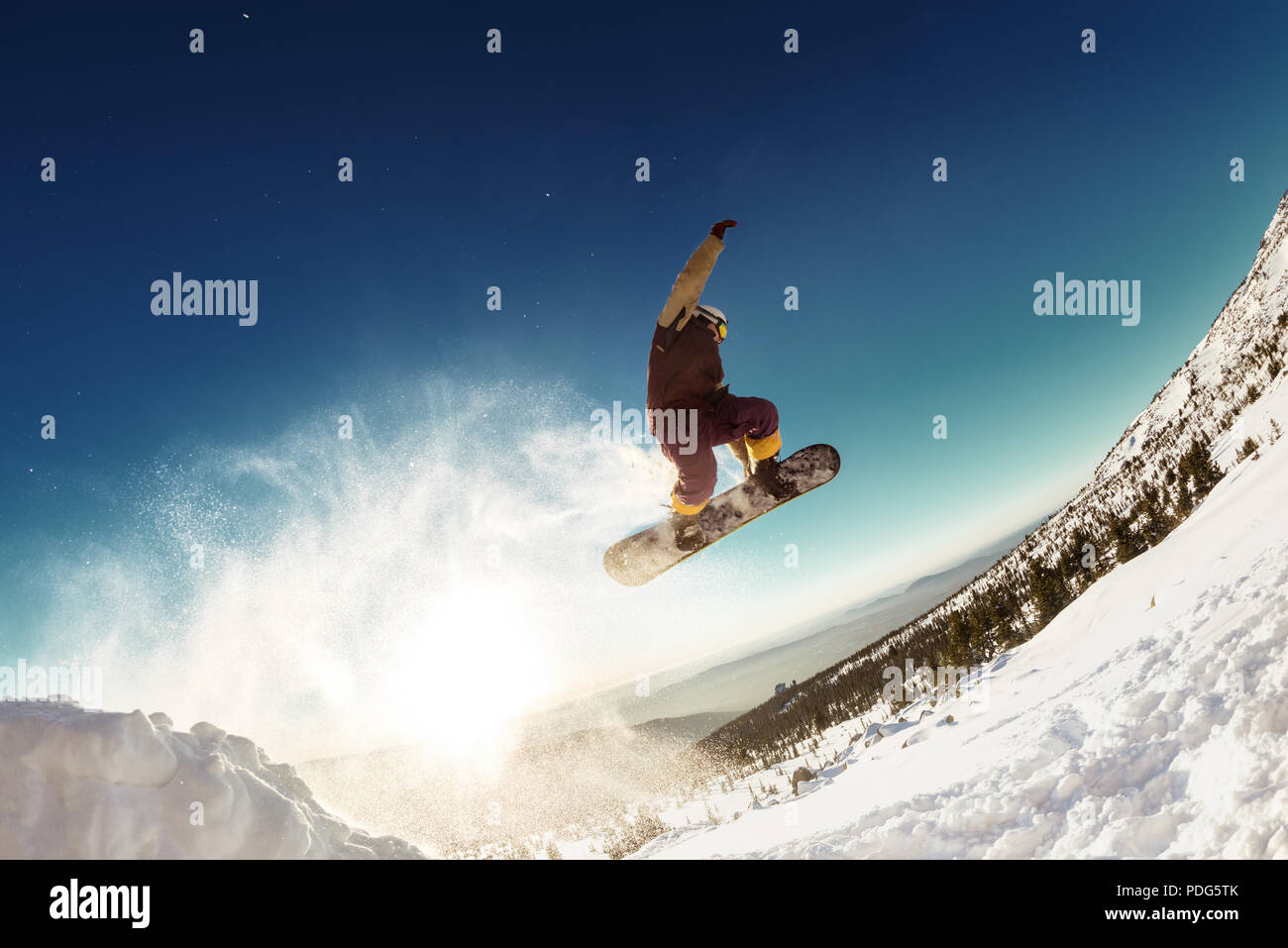 Snowboarder saute pour longue distance à partir de départ Banque D'Images