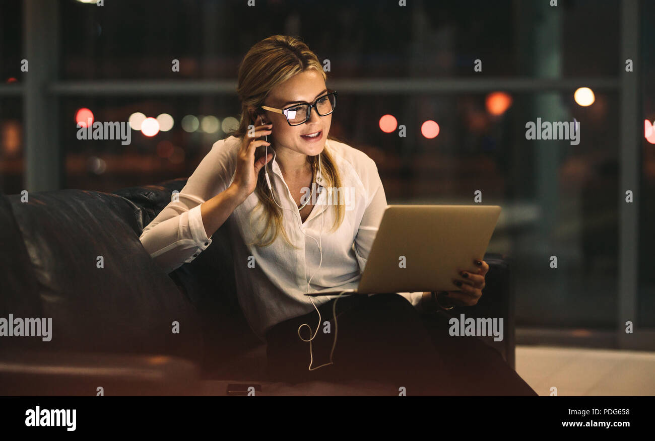 Businesswoman working in office tardif, faire un appel vidéo avec tablette numérique. Travail professionnel féminin à la fin de l'office et de faire un appel vidéo. Banque D'Images