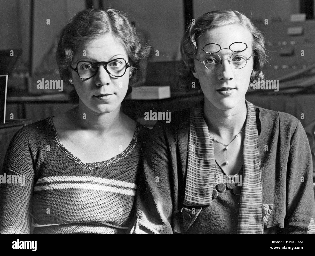1930 verres. Deux femmes chacune portant une paire de lunettes présentées comme la nouvelle forme de lunettes et des archets. À gauche 1935 ans forme des verres et bow. Le droit à une paire de lunettes avec qui combine deux jeux de lentilles. Un ensemble pour la lecture et l'autre pour l'usure, facilement plié vers le haut et vers le bas en fonction de la situation. Angleterre 1935 Banque D'Images