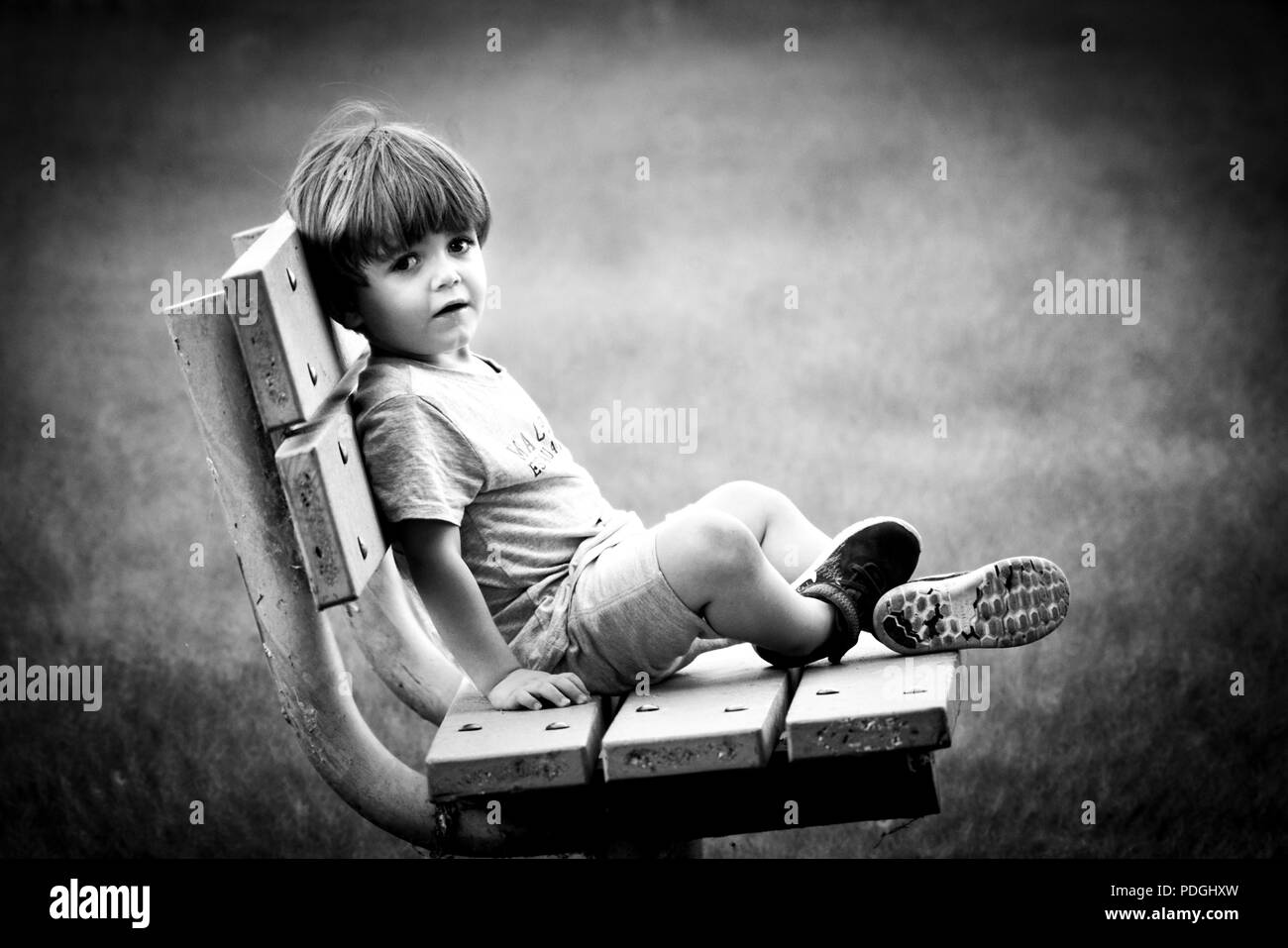 Montréal, Canada, le 4 août 2018. Portrait noir et blanc d'un jeune garçon assis sur le banc de parc.Credit:Mario Beauregard/Alamy Live News Banque D'Images