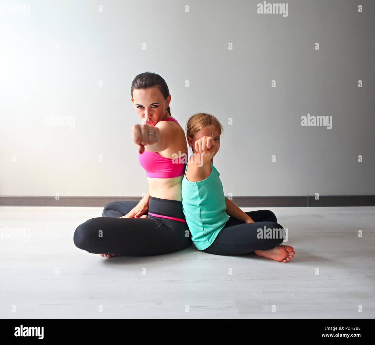 Young woman having fun with kid après le yoga. Famille sport concept Banque D'Images