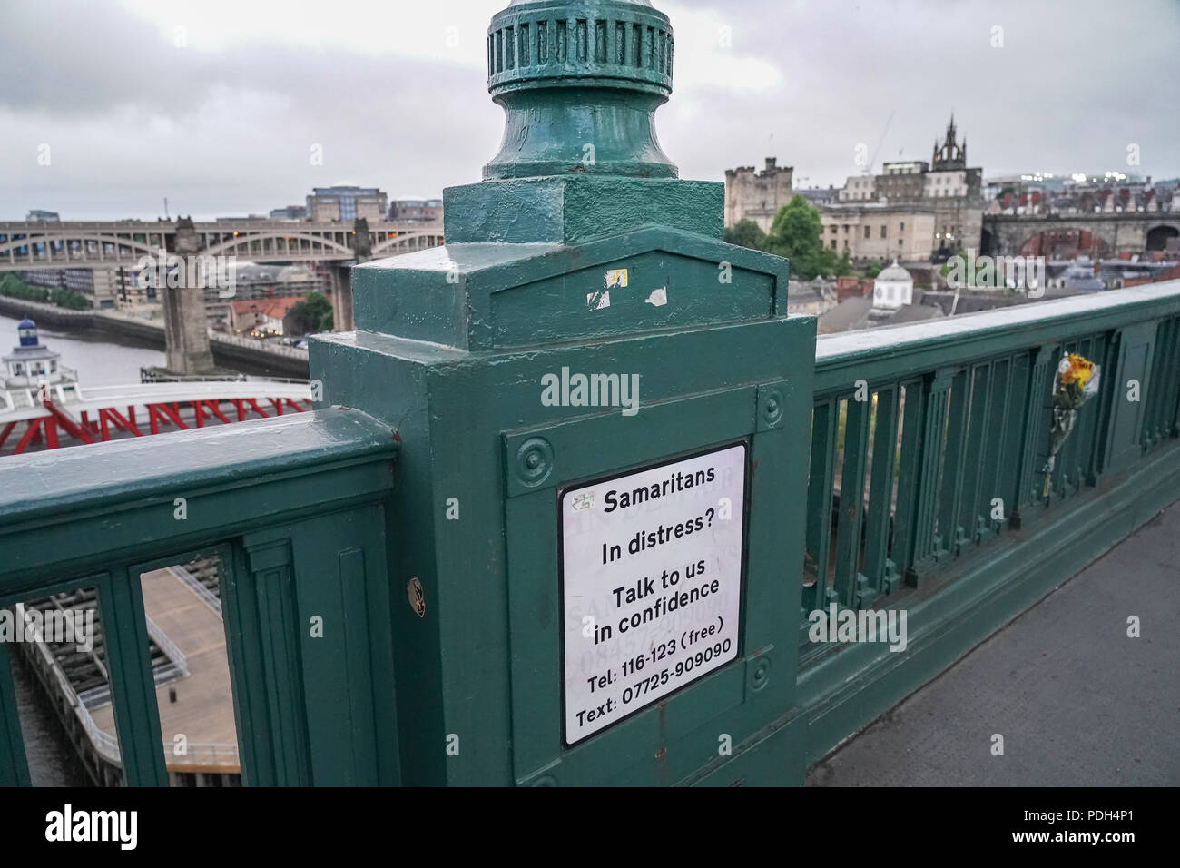 Fleurs commémorative à côté d'un panneau pour les Samaritains sur un pont de la ville de Newcastle, au Royaume-Uni. Date de la photo : le lundi 11 juin 2018. Photo : Roger Garf Banque D'Images