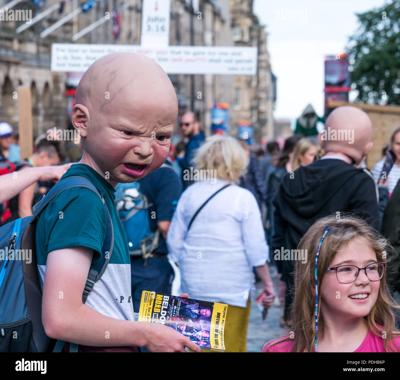 Edinburgh, Ecosse, Royaume-Uni. 9 août 2018. Edinburgh Fringe Festival, Royal Mile, Édimbourg, Écosse, Royaume-Uni. On a sunny day festival le festival de rue organisé Virgin Money est emballé avec les gens et les artistes. Une frange interprète vêtu d'un horrible tête bébé interagit avec les piétons distribuant des dépliants Banque D'Images