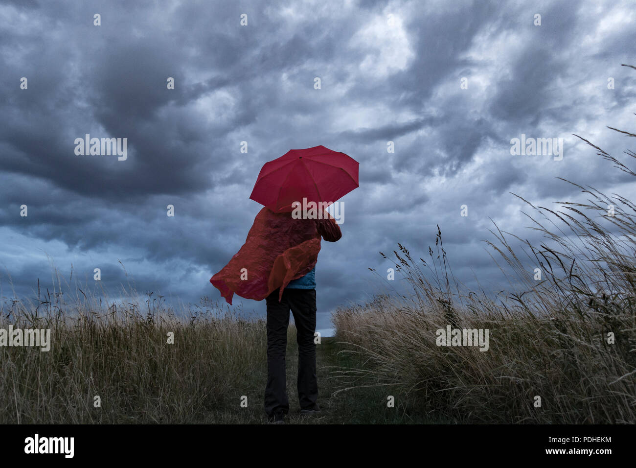 Un homme perd son parapluie sur un jour de tempête en Angleterre. UK Banque D'Images
