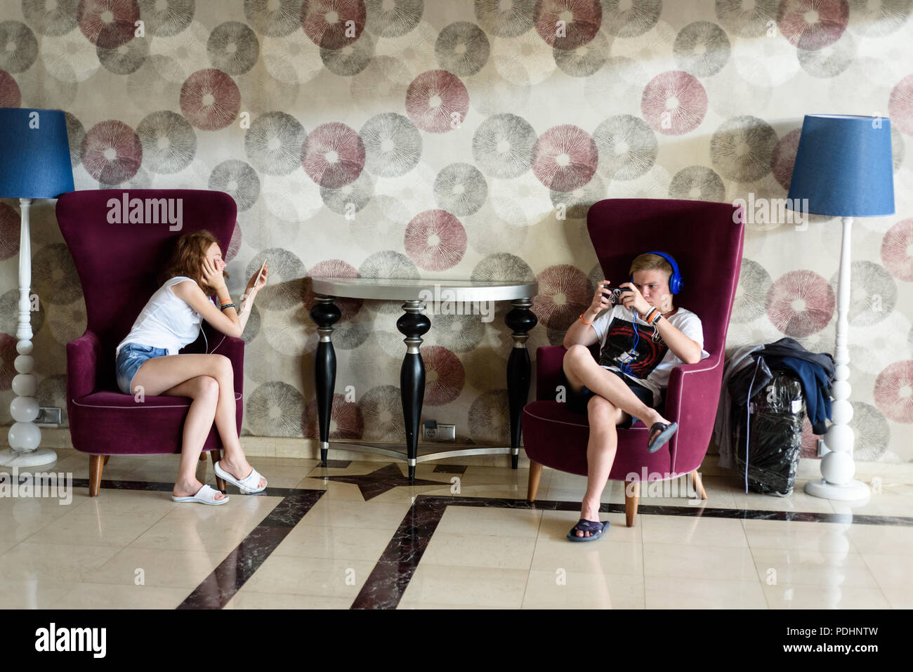 ANTALYA, TURQUIE, 13ème Juillet 2018 - Deux jeunes touristes utilisent leurs smartphones dans une zone wifi d'un hotel à Antalya dans l'été de 2018 Banque D'Images