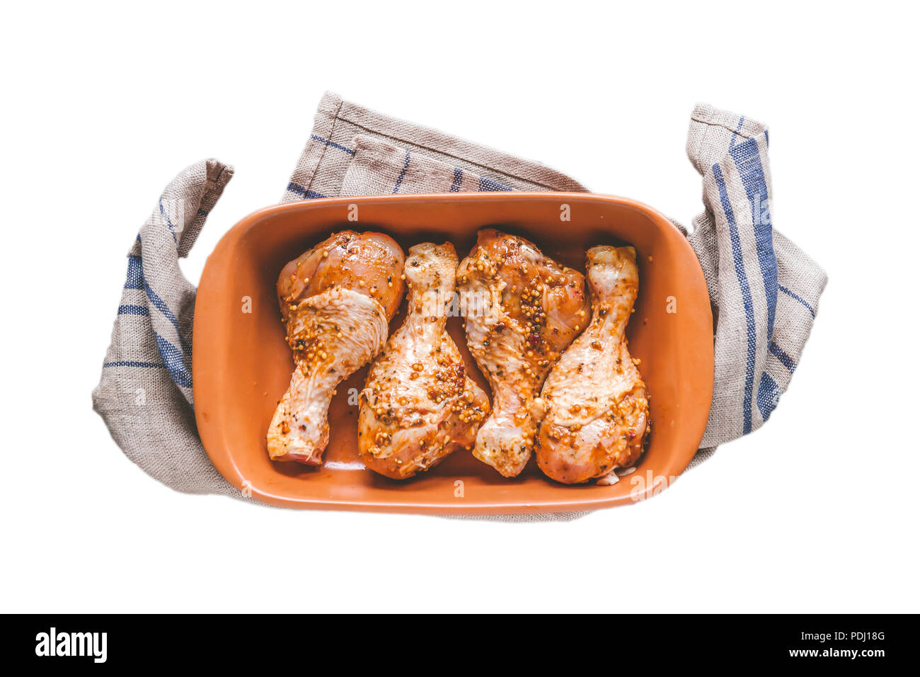 Pilons de poulet crus marinés dans la faïence céramique forme isolé sur fond blanc. Banque D'Images