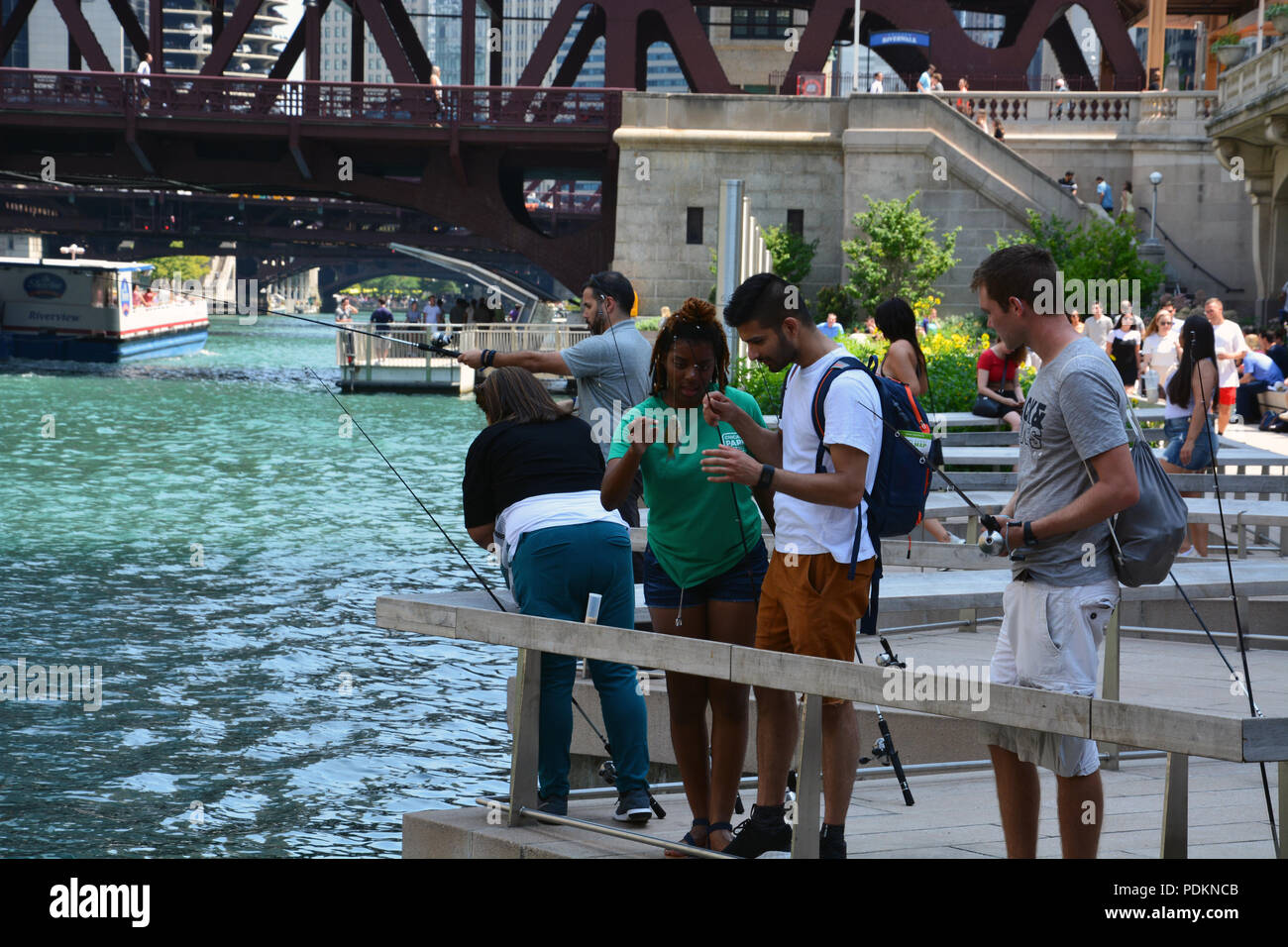 Les pêcheurs sur le Riverwalk, jardins flottants attraper une perche dans le cadre du Chicago Park District 'libre' à la jetée de pêche programme. Banque D'Images