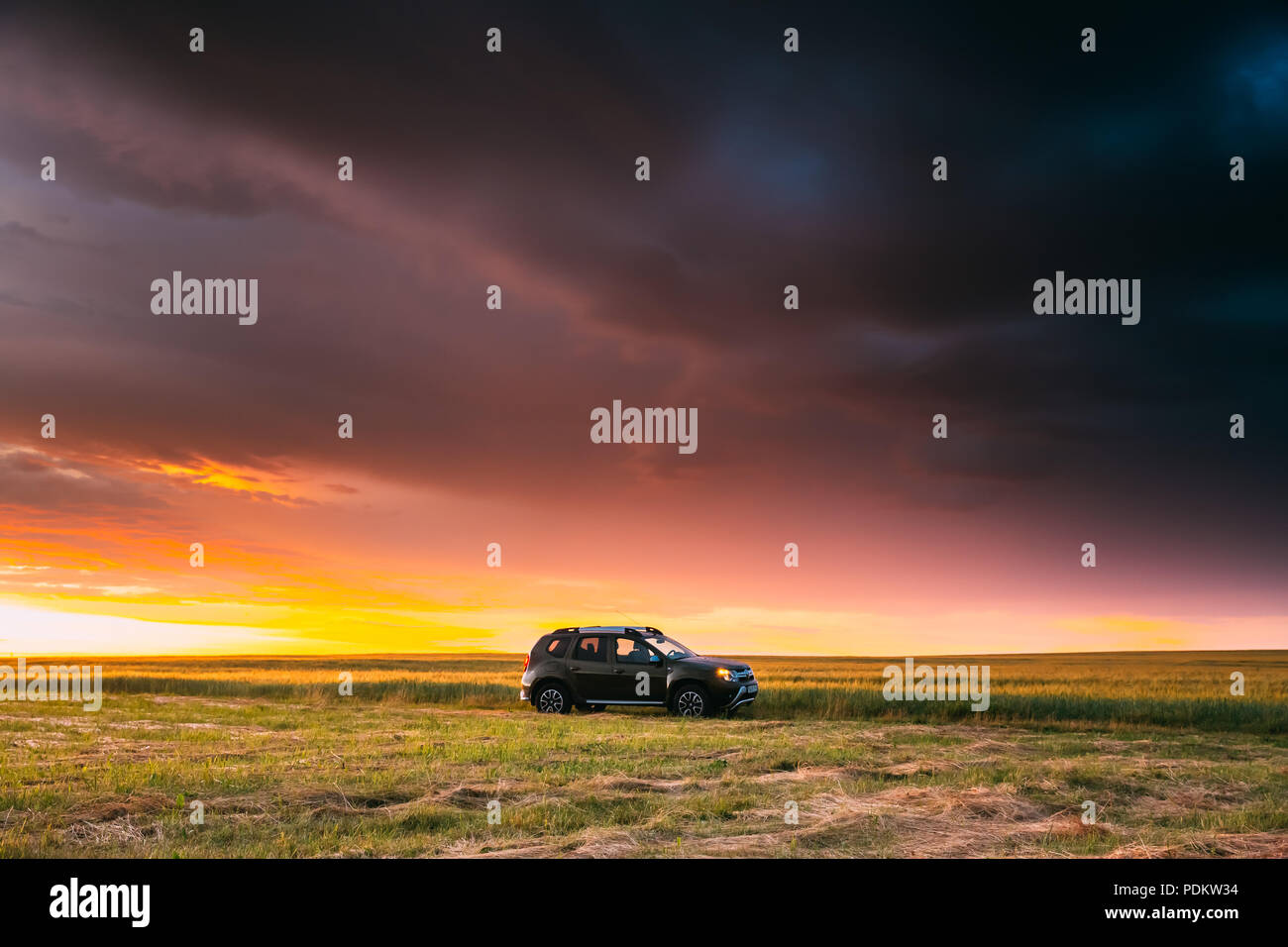 Gomel, Bélarus - Juin 22, 2018 : voiture Renault Duster ou Dacia Duster Suv dans la route à travers champs de blé d'été à l'heure du coucher du soleil magnifique. Duster Produit Inscrivez-vous Banque D'Images