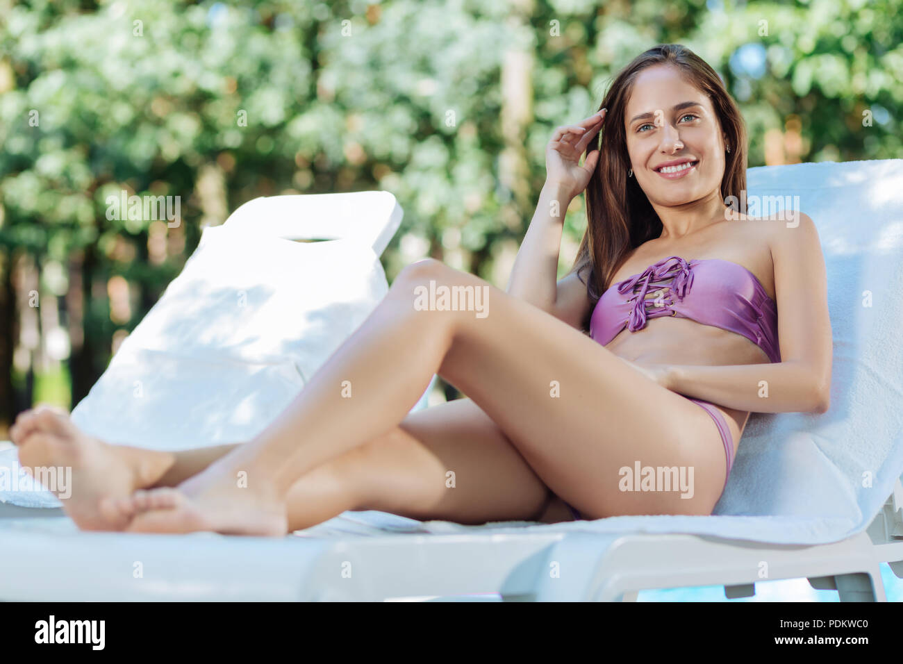 Dark-haired woman wearing purple maillot de bain de soleil Banque D'Images