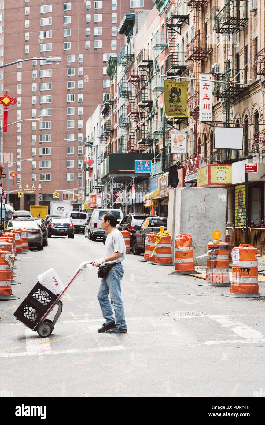 La ville de New York, USA - 20 juin 2018 : l'Asiatique homme poussant un chariot dans Chinatown street dans le centre-ville de New York Banque D'Images