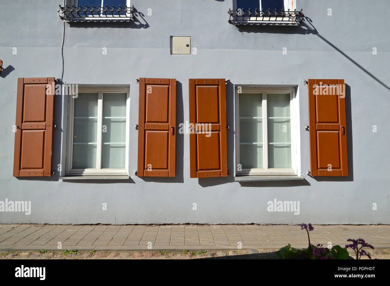 Fenêtres avec volets sur une petite rue à Vilnius Banque D'Images