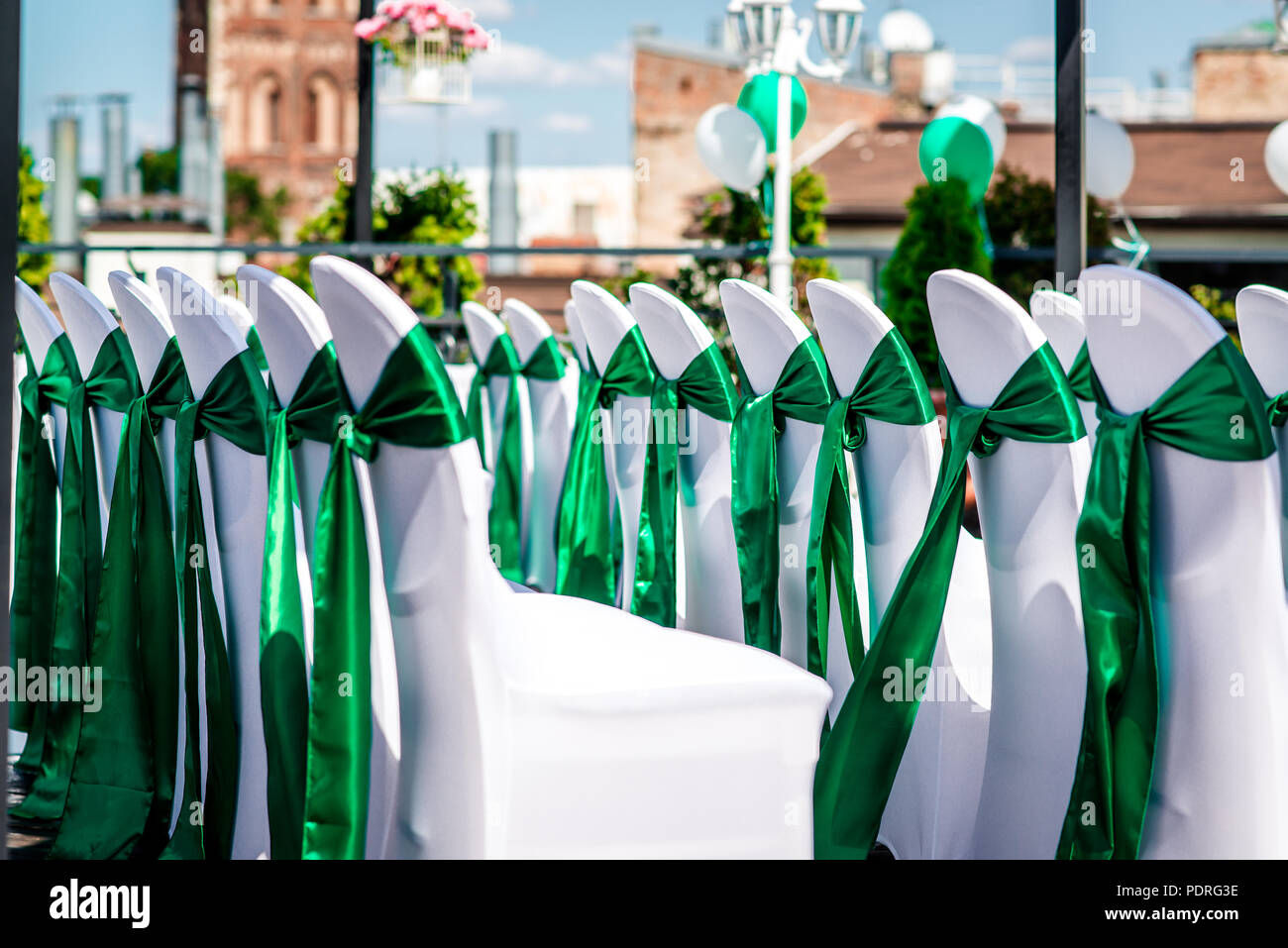 Chaises de mariage blanc avec ruban vert à l'extérieur Banque D'Images