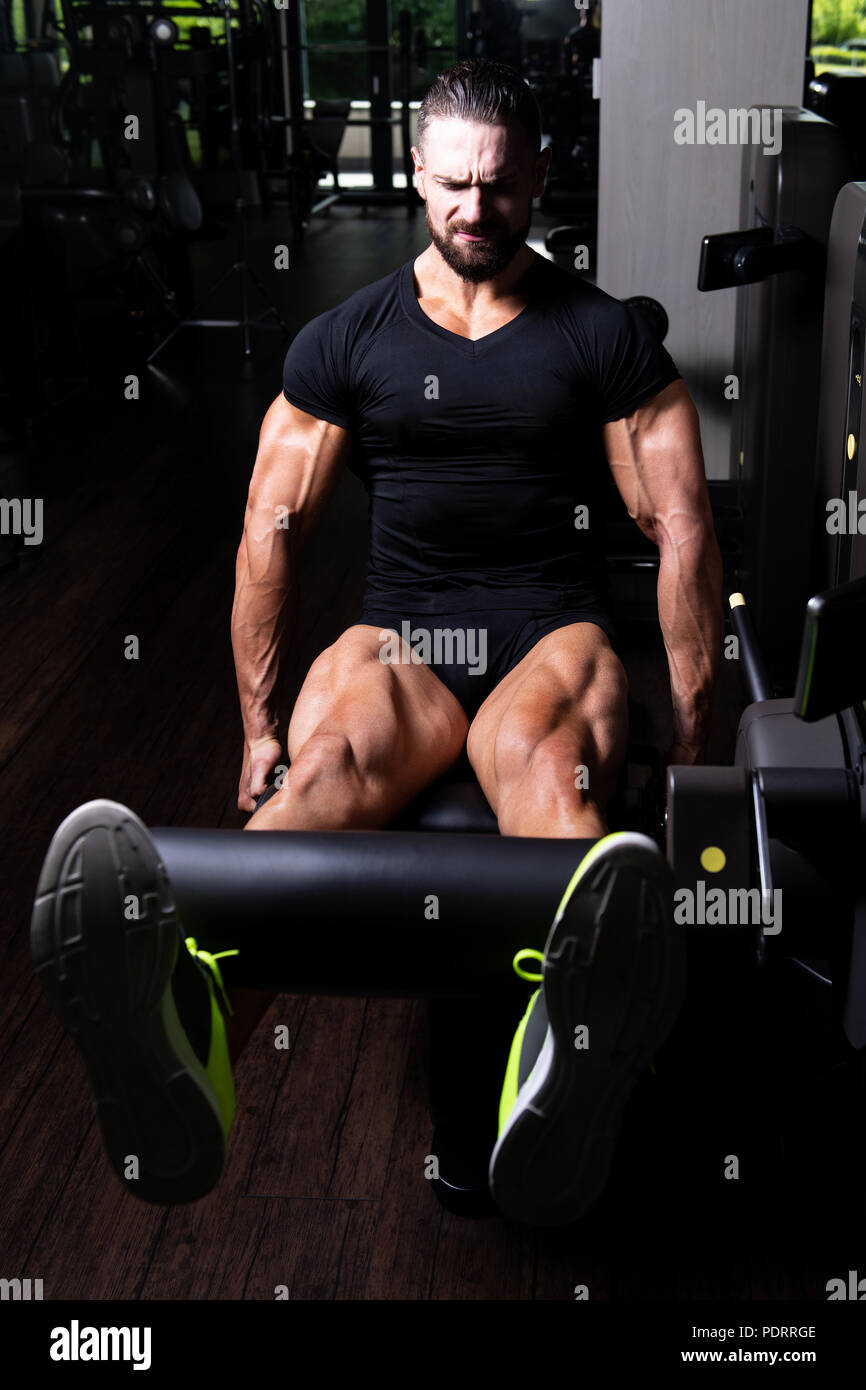 Les jambes Close Up - Homme faisant la jambe avec la machine dans une salle de sport Banque D'Images