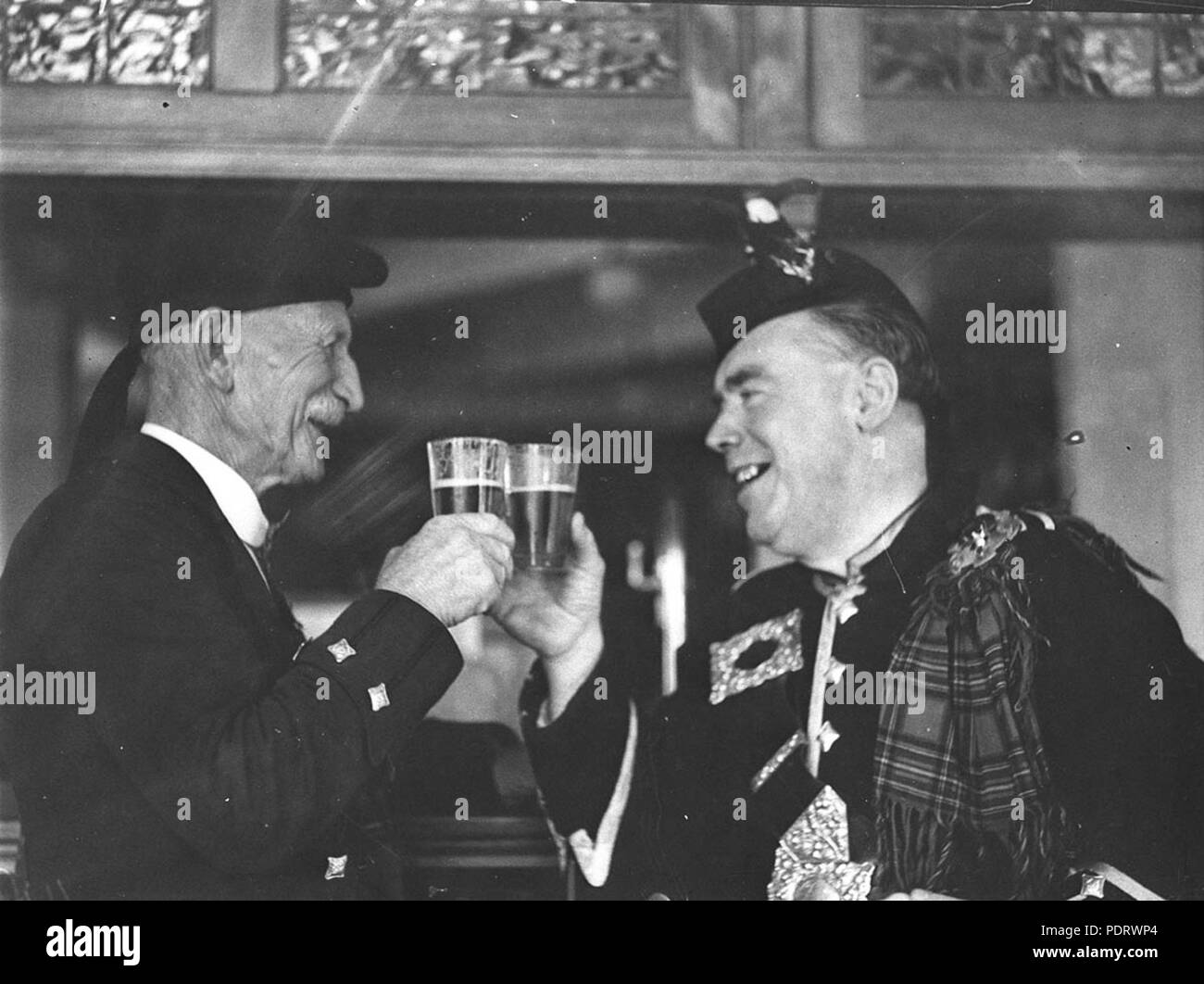 161 43465 SLNSW Deux Highlanders clink leurs verres de bière au sociétés Highland Games calédonien Banque D'Images
