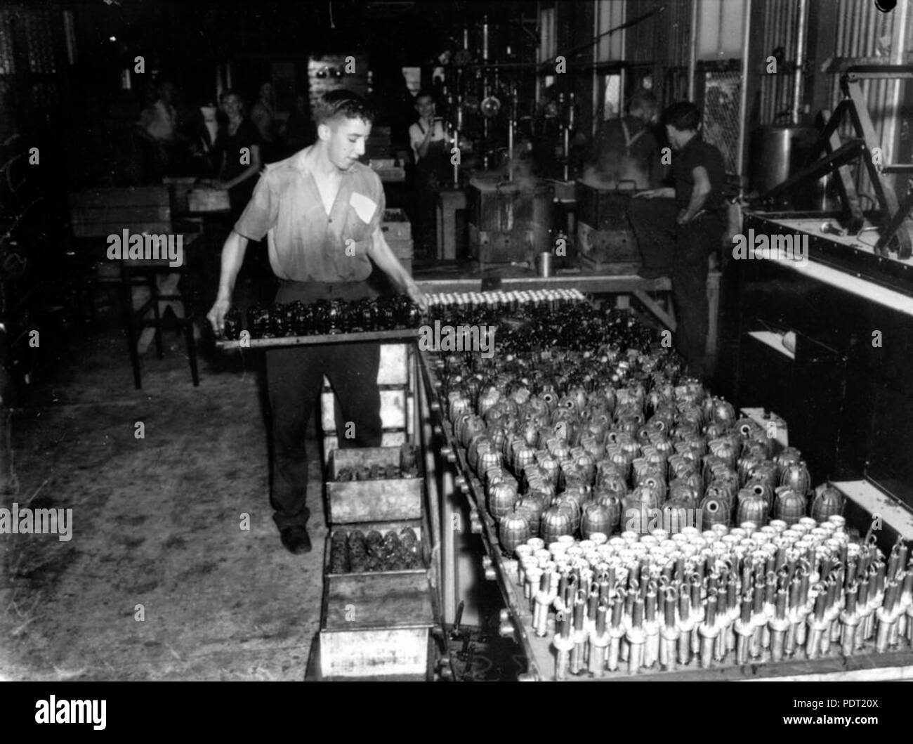 202 1 106088 StateLibQld Factory worker stacking caisses de grenades à main, Brisbane, ca. 1942 Banque D'Images