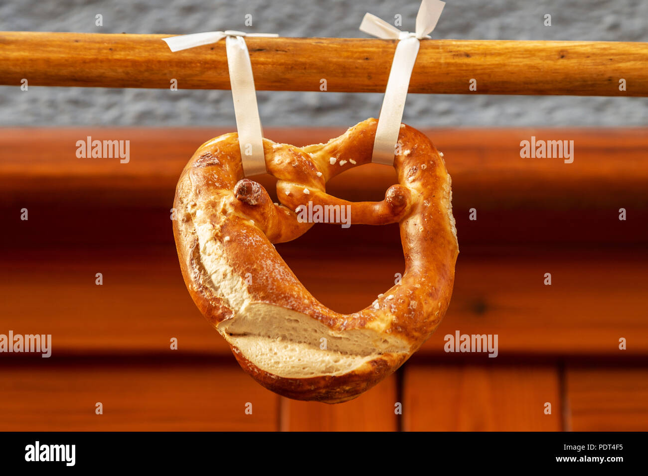 Un bretzel ou brezel en allemand accroché sur une barre en bois, typique de la bière bavaroise et snack Banque D'Images