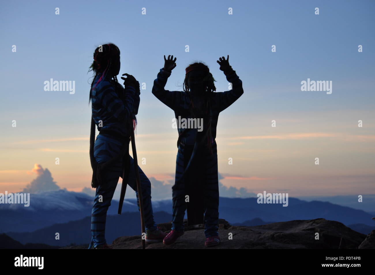 Chronologie de Silhouette 2 jeunes filles dans le crépuscule du matin debout sur le Ampucao Sta. En attendant le lever du soleil les crêtes Fe au Mont Ulap dans Itogon, Banque D'Images