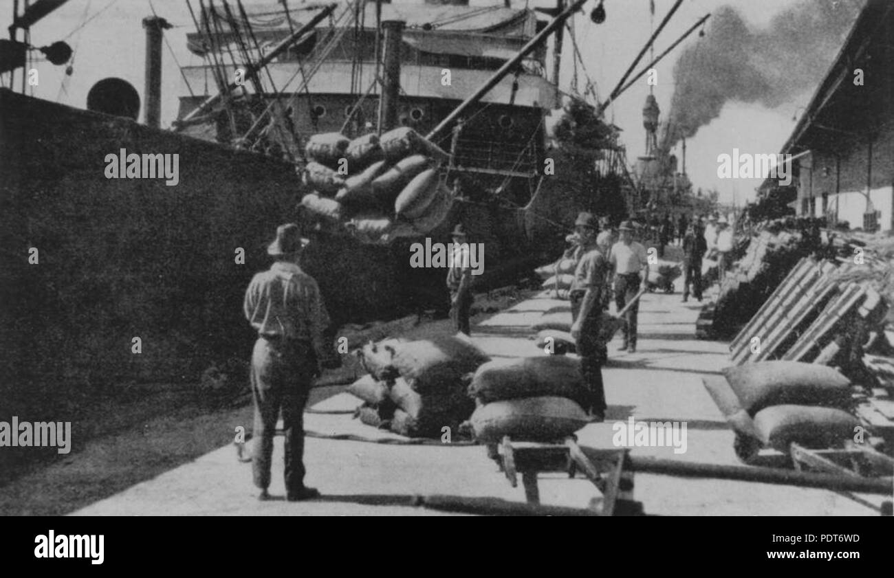 237 1 165667 StateLibQld Chargement dans la cale du navire, Cairns, ca.1921 Banque D'Images