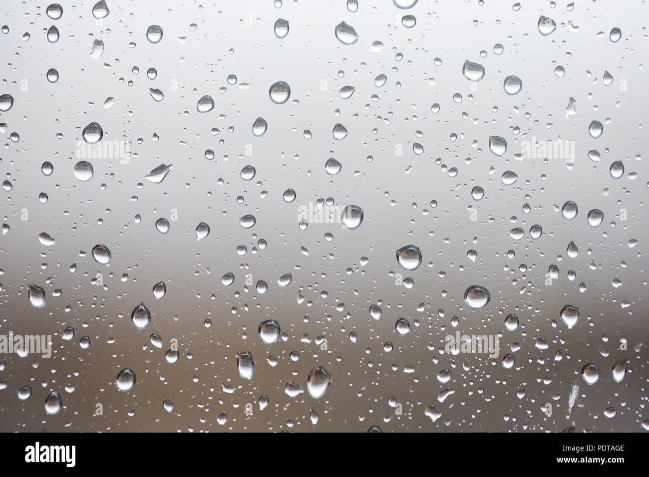 Les gouttelettes d'eau de pluie, de la pluie ou de gouttes, s'installer sur une fenêtre en verre pendant un orage Banque D'Images