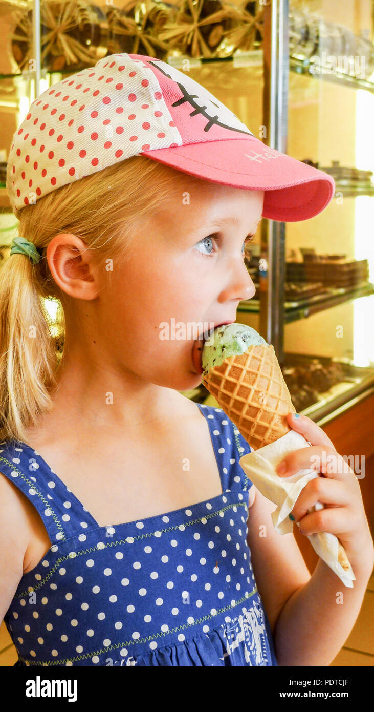 Blonde fille enfant enfant manger un cône de glace, vacances d'été, France petite blonde fille polka point, enfance concept souvenirs moments Banque D'Images