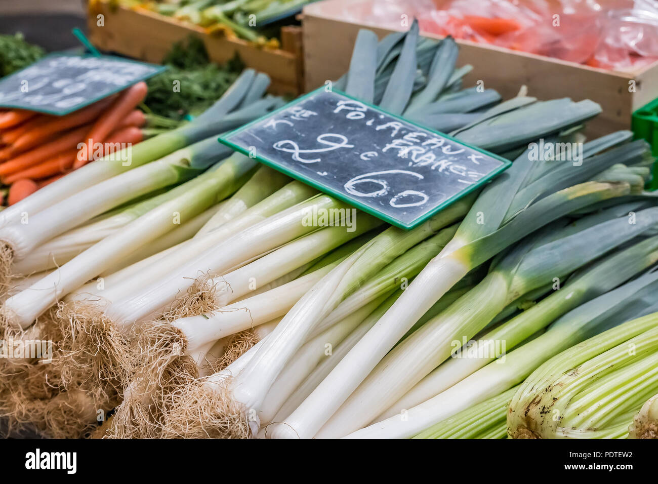 Poireaux frais avec une craie à la main board : balise à un marché des fermiers locaux outdoor en France Banque D'Images