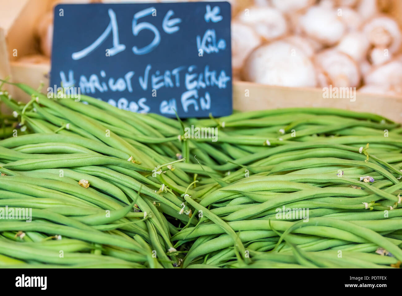 Haricots verts frais avec une étiquette de prix tableau manuscrit dans un marché de producteurs en plein air en France Banque D'Images