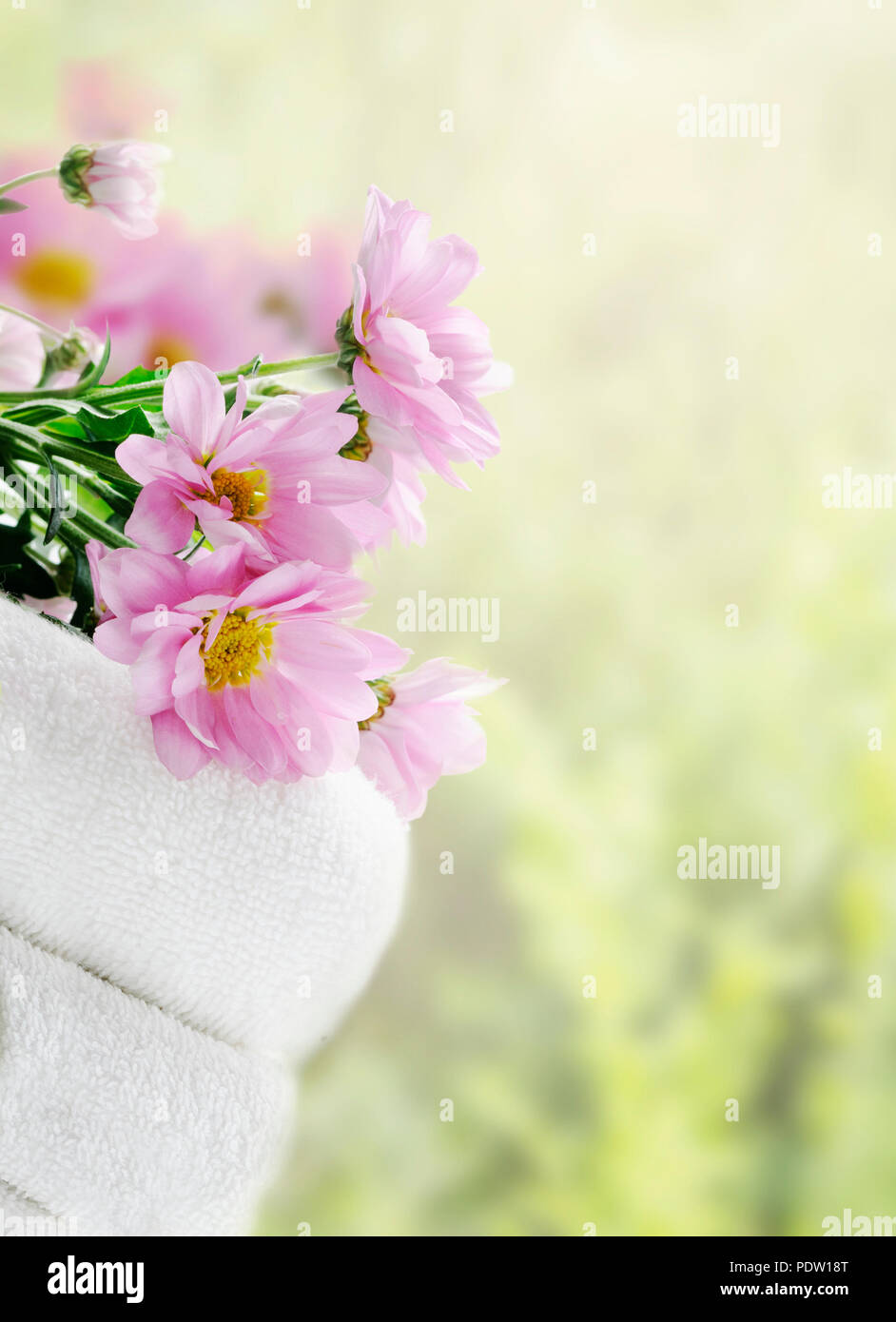 Des serviettes propres blanc et fleurs fraîches avec fond naturel vert Banque D'Images