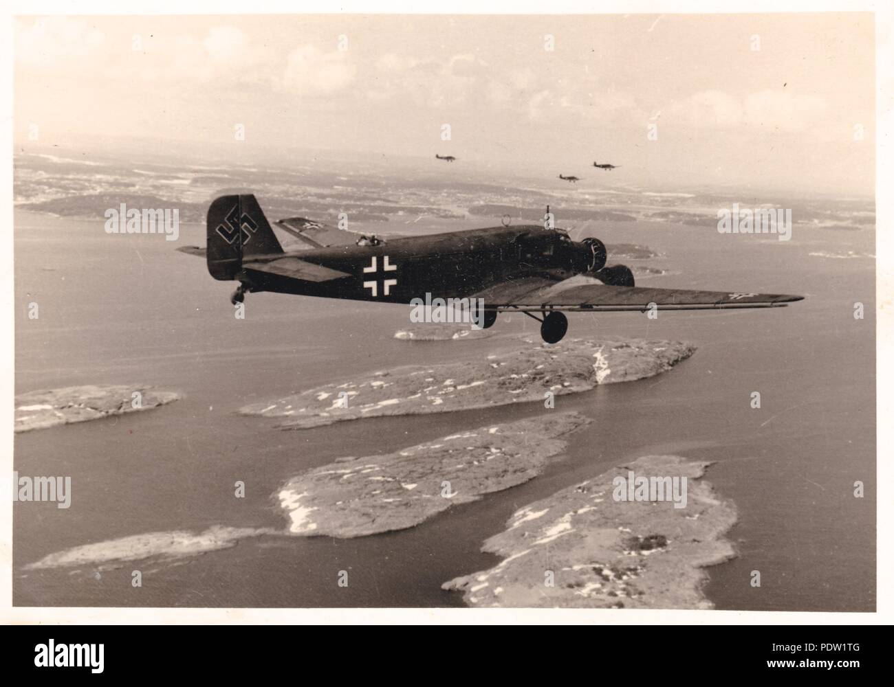 Droit de l'album photo de Karl Oberfeldwebel Gendner de 1. La Kampfgeschwader 40 Staffel, air-air : photographie d'un vol de Junkers Ju 52/3m de KGzbV 1 en route de la Norvège à Aalborg au Danemark, en mai 1940. L'aéronef le plus proche est 1Z +GK de 2./KGzbV Staffel 1. D'intérêt est la croix gammée surdimensionnée sur la queue de cet avion. Karl Gendner a été un projet pilote avec 3./KGzbV 1 en ce moment. Banque D'Images