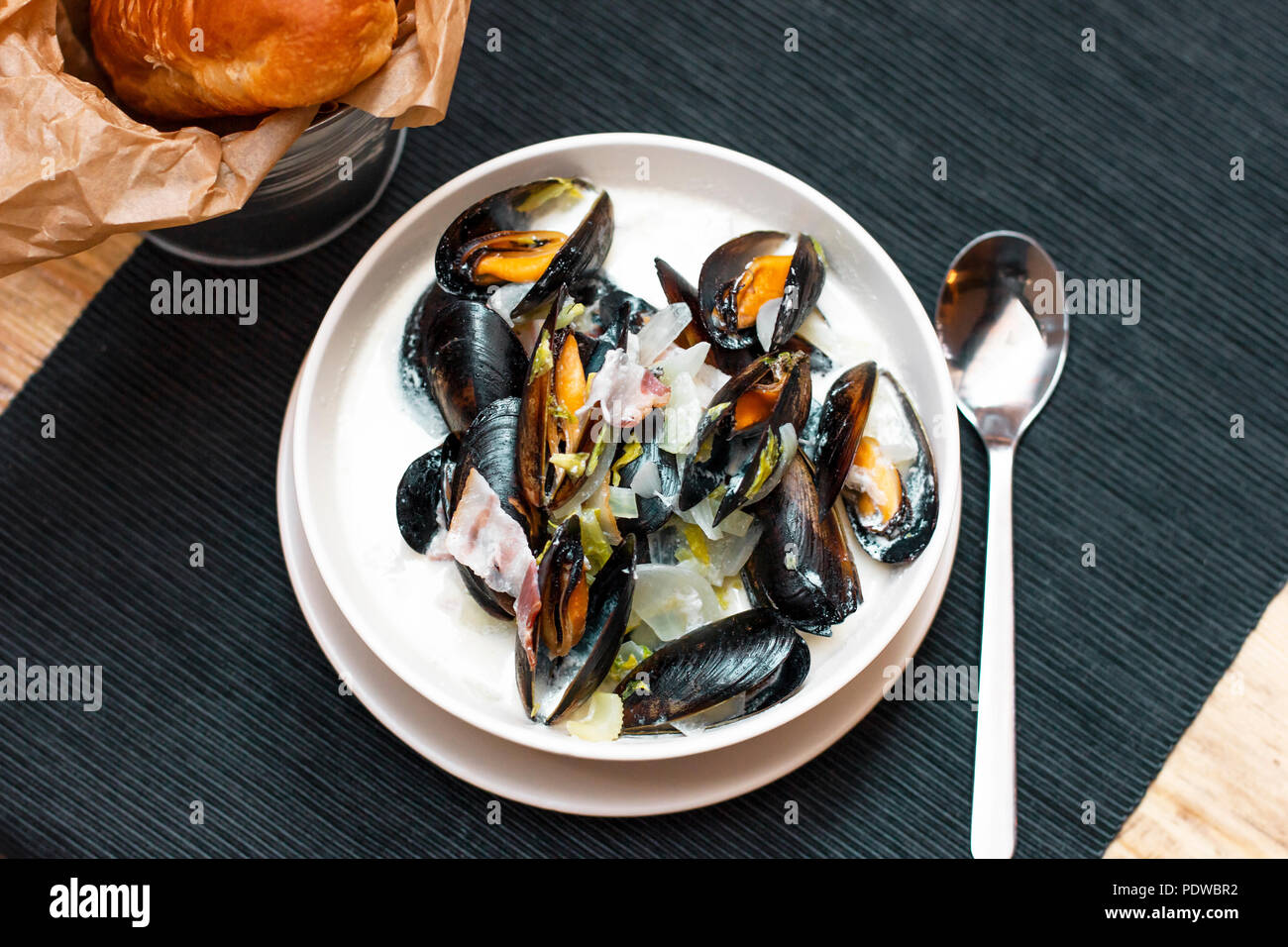 Moules aux oignons et lardons à la crème en plaque profonde Banque D'Images