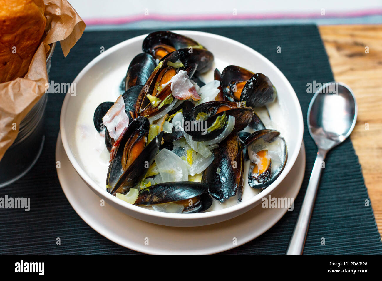 Moules aux oignons et lardons à la crème en plaque profonde Banque D'Images