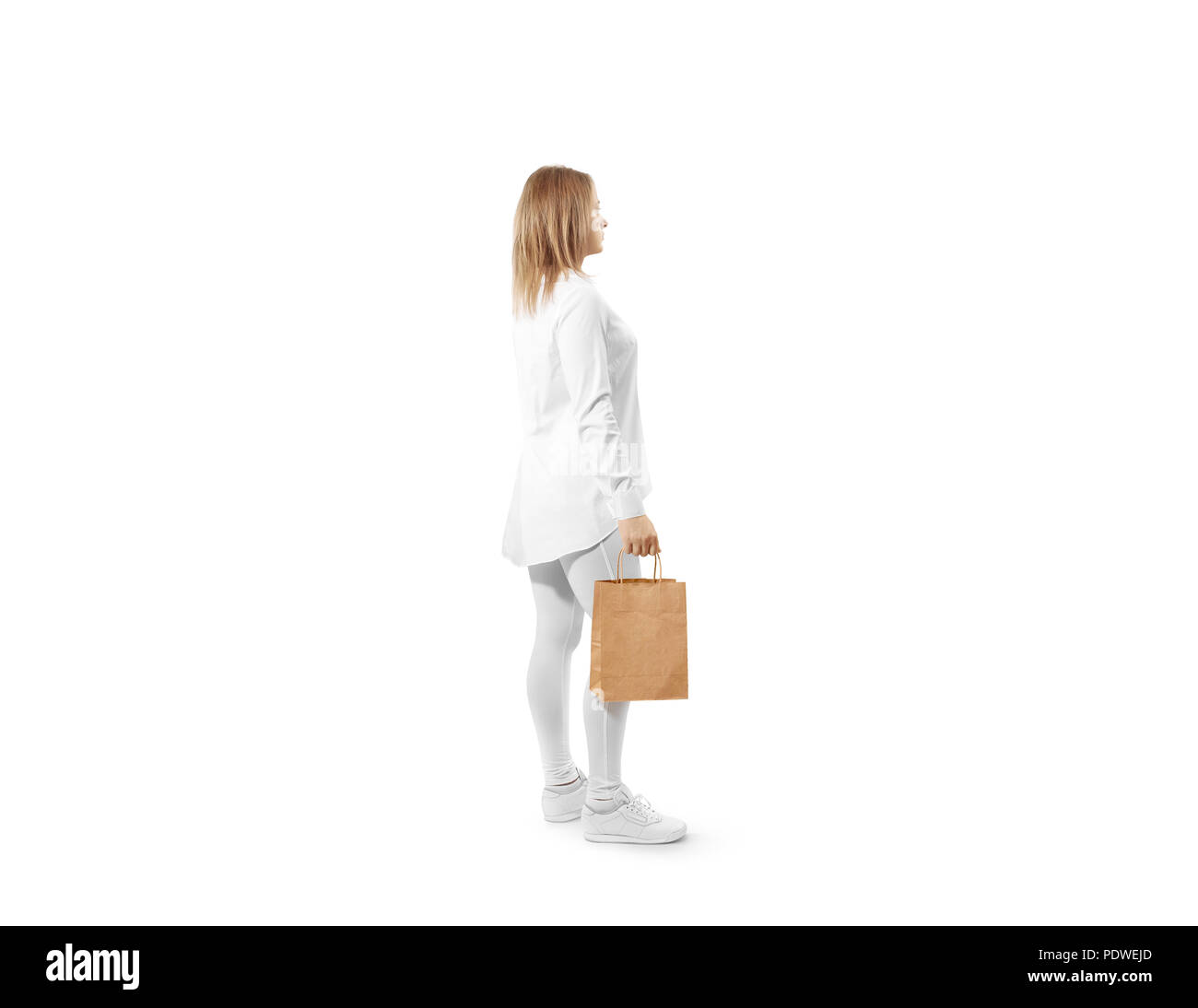 Woman holding blank brown sac en papier artisanal des maquettes, isolé. Personne de tenir acheter pack de texture kraft immersive. Modèle de marque claire shop bagful. Banque D'Images